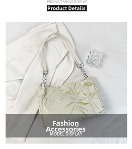 Detail of cream shoulder bag with bamboo leaf print on white blazer and silver chain strap