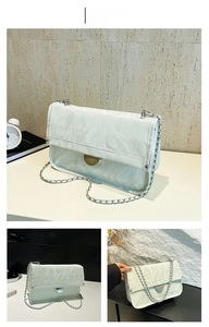 Detail of mint green chain shoulder bag with textured pleats and silver metal lock