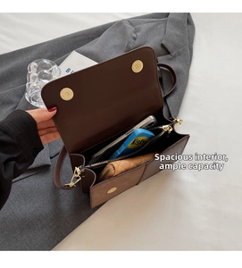 Interior detail of a brown crossbody bag showing spacious compartments and a magnetic flap