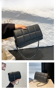 Detail of black quilted chain bag with matte texture and silver metal shoulder strap