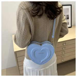 Borsa a tracolla azzurra a forma di cuore con goffratura mostrata su una modella