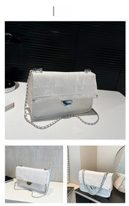 Close-up of white glossy crinkled fabric shoulder bag with silver chain strap and metal clasp