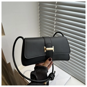 Close-up of black PU leather shoulder bag with gold H-shaped buckle and knotted strap