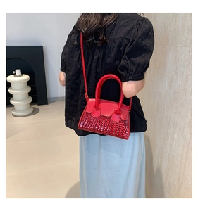 Piccola borsa rossa quadrata con trama coccodrillo indossata da una modella per misura