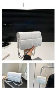 Detailed views of white quilted crossbody bag with silver chain strap and flap closure