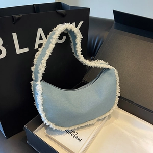 Chic blue denim hobo bag with white faux shearling trim and top zipper closure