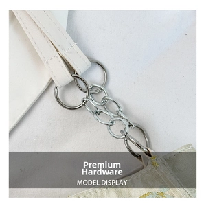 Macro shot of silver metal rings and chain links connecting the white leather strap