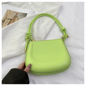 Detailed view of lime green PU leather handbag with decorative knotted handle and gold hardware