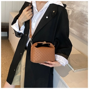Brown retro crossbody bag with diamond textured pattern shown on a model