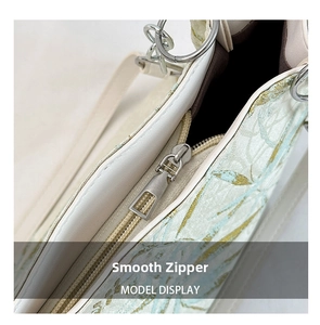 Close-up of smooth metal zipper and exquisite jacquard embroidery fabric on handbag