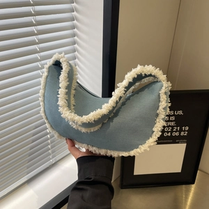 Blue denim crescent underarm bag with white sherpa trim and stylish zipper closure