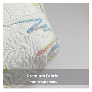 Close-up of white canvas fabric with quilted texture and colorful beaded embroidery details
