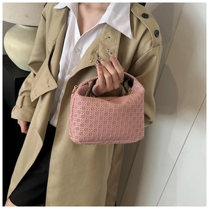 Detailed shot of a pink woven mini handbag with textured pattern and gold hardware