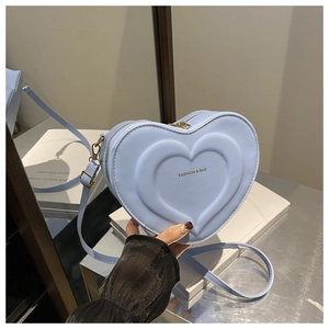 Dettaglio borsa a tracolla celeste con rilievo a cuore e logo FASHION dorato