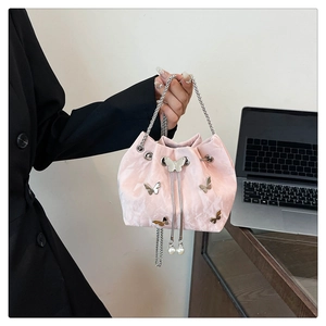 Detailed shot of pink satin drawstring bucket bag with silver butterfly charms and pearls