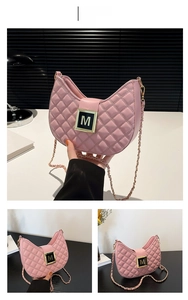 Detail of pink quilted half-moon shoulder bag with gold M-logo and chain strap