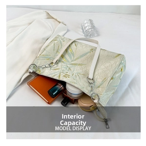 Interior capacity view of embroidered cream tote bag with floral patterns and daily items