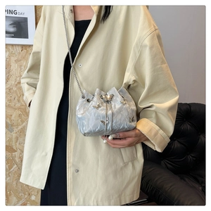 Detail of silver metallic drawstring bag with 3D butterfly ornament and pearl charms