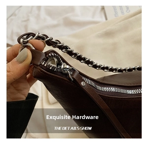 Détail du sac cabas marron foncé avec fermeture éclair argentée et bandoulière en chaîne