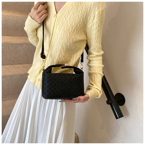 Chic black woven textured handbag styled with white skirt for elegant commute outfit