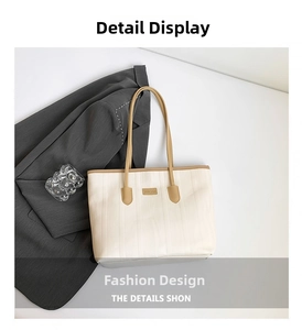 Detail of cream tote bag with vertical embossed texture and brown leather straps