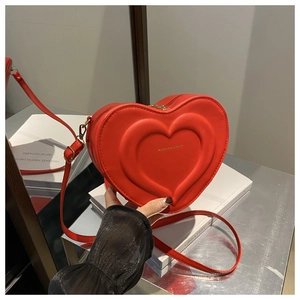 Dettaglio della borsa a tracolla rossa a forma di cuore con goffratura e logo oro
