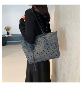Detail showing grey polka dot tote with bow embroidery and silver metal bow ornament