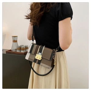 Detailed view of women's geometric color-block crossbody bag worn by a model