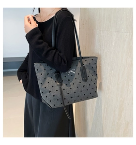 Close-up of polka dot pattern and silver bow buckle on a gray fabric tote bag