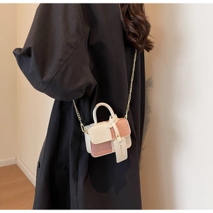 Close-up of pink and white contrast mini square bag with gold chain strap and top handle