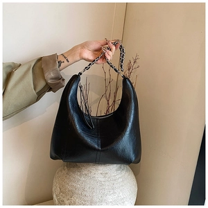 Détail du sac hobo noir avec texture cuir litchi et bandoulière en chaîne métal