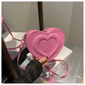 Dettaglio della borsa a tracolla rosa a forma di cuore con trama in rilievo e cinturino
