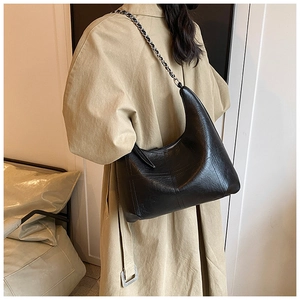 Détail du sac hobo noir matelassé avec bandoulière chaîne et texture plissée
