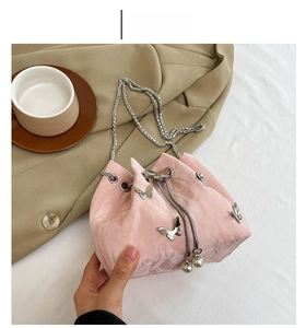 Detail of pink pleated bucket bag featuring silver metal butterflies and pearl drawstring