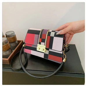 Close-up of geometric patchwork crossbody bag with elegant gold metal flip lock clasp