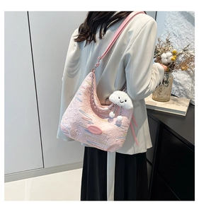 Detailed texture of pink textured tote bag featuring colorful embroidery and cloud charm