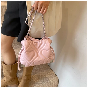 Close-up of pink tote bag with heart-shaped quilting and chain strap detail