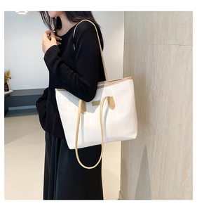 Detail view of cream tote bag with khaki handles and vertical textured finish on model