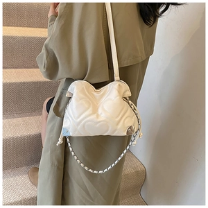 Detail of cream chain shoulder bag with heart quilting and metallic corner accents
