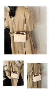 Detail of cream woven crossbody bag with metal accents and adjustable shoulder strap