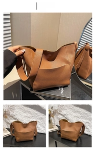 Close-up of brown litchi pattern leather bucket bag showing texture and wide strap