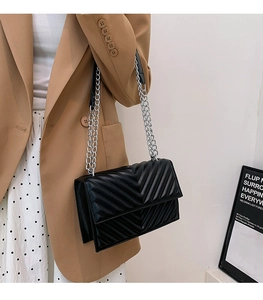 Vue latérale du sac bandoulière matelassé noir avec chaîne argentée et coutures en V