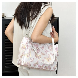 Detail of white embroidery underarm bag with pink butterflies and silver chain strap