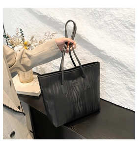Detail view of the black tote bag showing the vertical ripple texture and JINGPIN logo patch