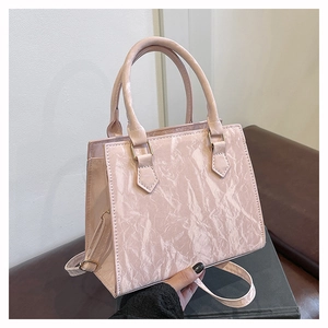 Detailed view of pink marble texture and pleated finish on a chic handbag with gold hardware