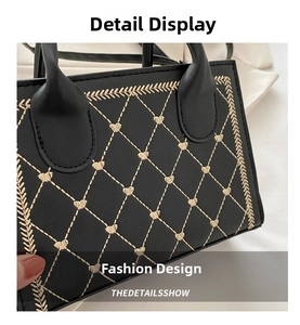 Close-up of black leather bag featuring gold heart embroidery and quilted textures