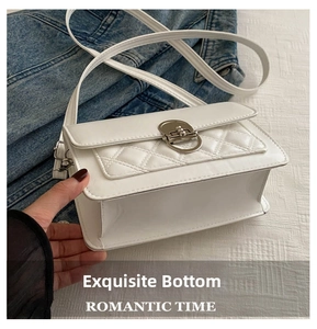 Detailopname van een witte crossbodytas met de dikke bodem en gewatteerde ruitvormige details
