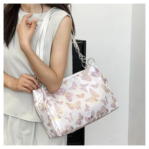 Detail of white tote bag with elegant purple butterfly embroidery and silver chain strap
