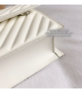 Vue détaillée du sac matelassé blanc montrant les plis en accordéon et les coutures
