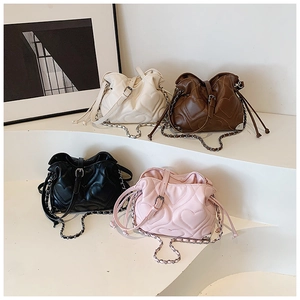 Detailed view of heart-quilted bucket bags in white, brown, black, and pink colors